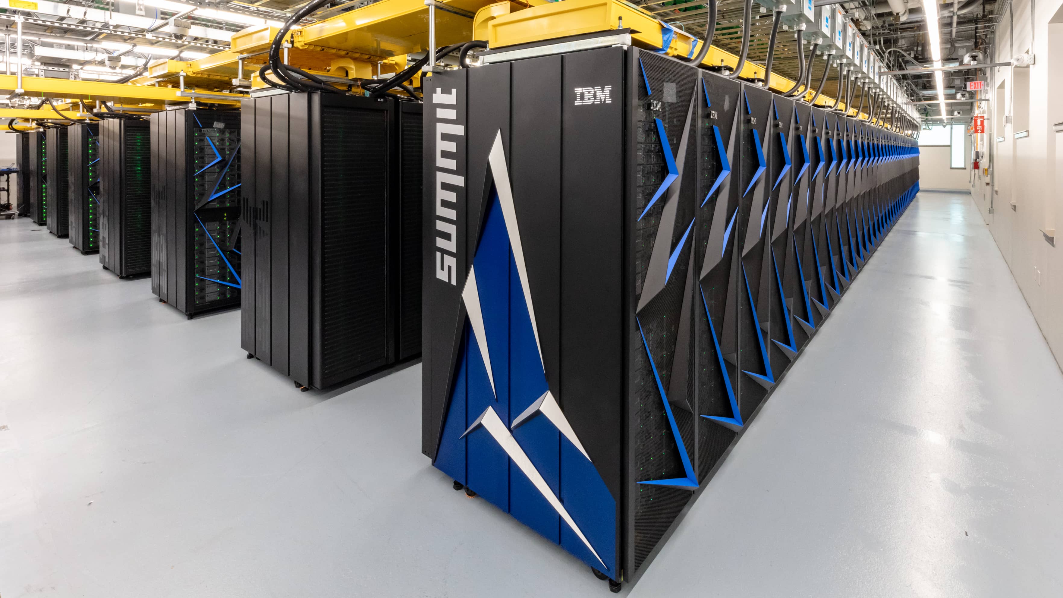 Rows of supercomputer cabinets in a bright machine hall